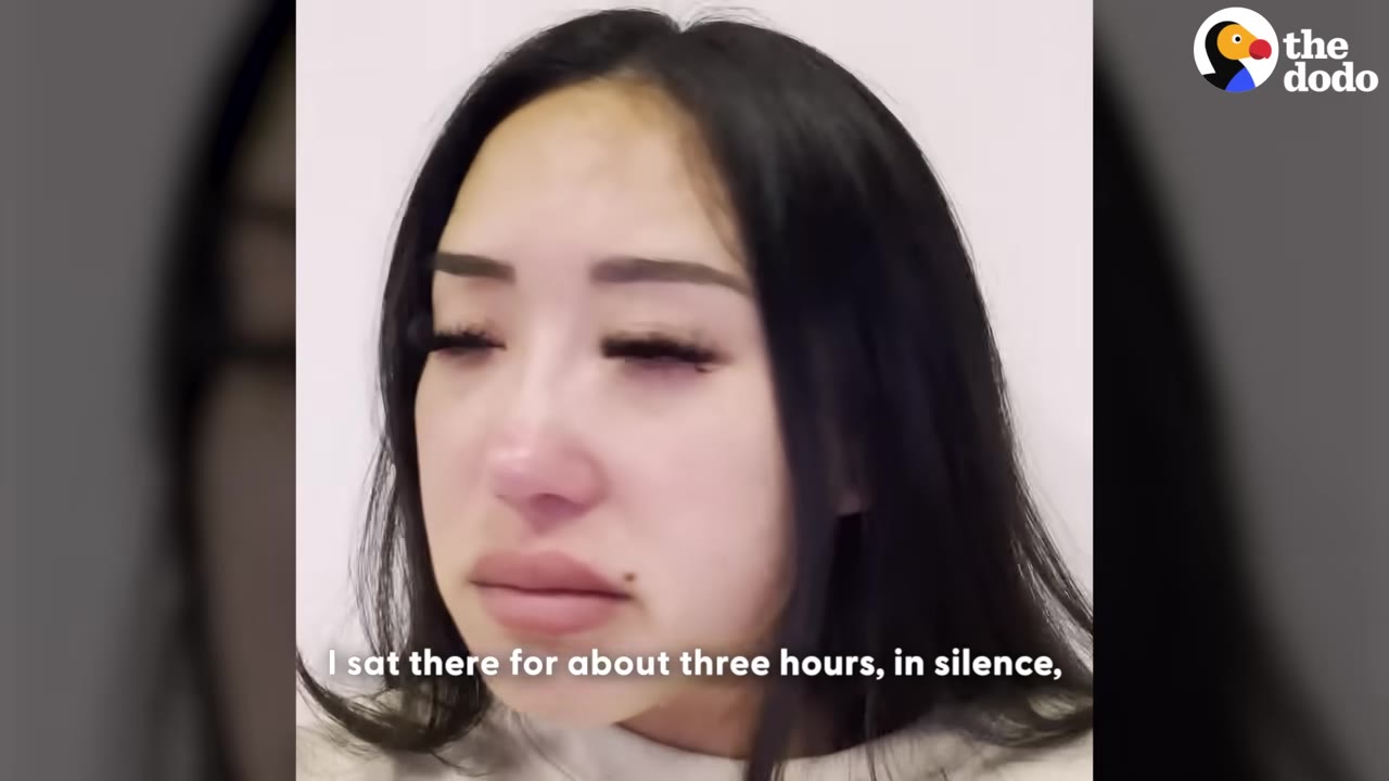 A close-up of a woman with long dark hair looking down with a sad, tearful expression, with a subtitle that reads, 'I sat there for about three hours, in silence,'.