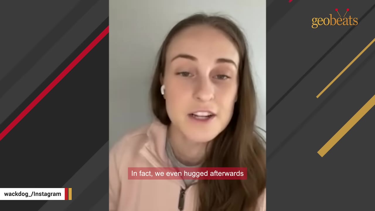 A young woman with long brown hair wearing a pink jacket and white earbuds speaks directly to the camera, with a subtitle that reads, 'In fact, we even hugged afterwards'.