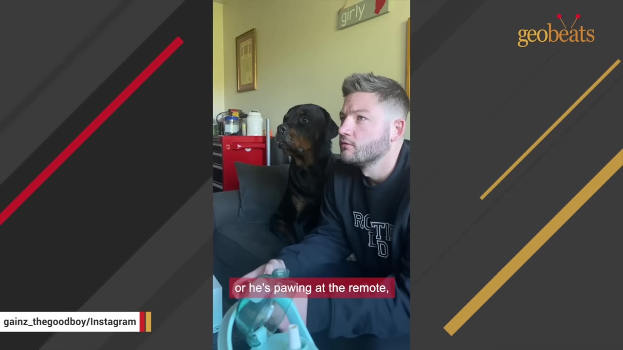 A man sitting on a couch with a Rottweiler sitting right next to him, both looking in the same direction.