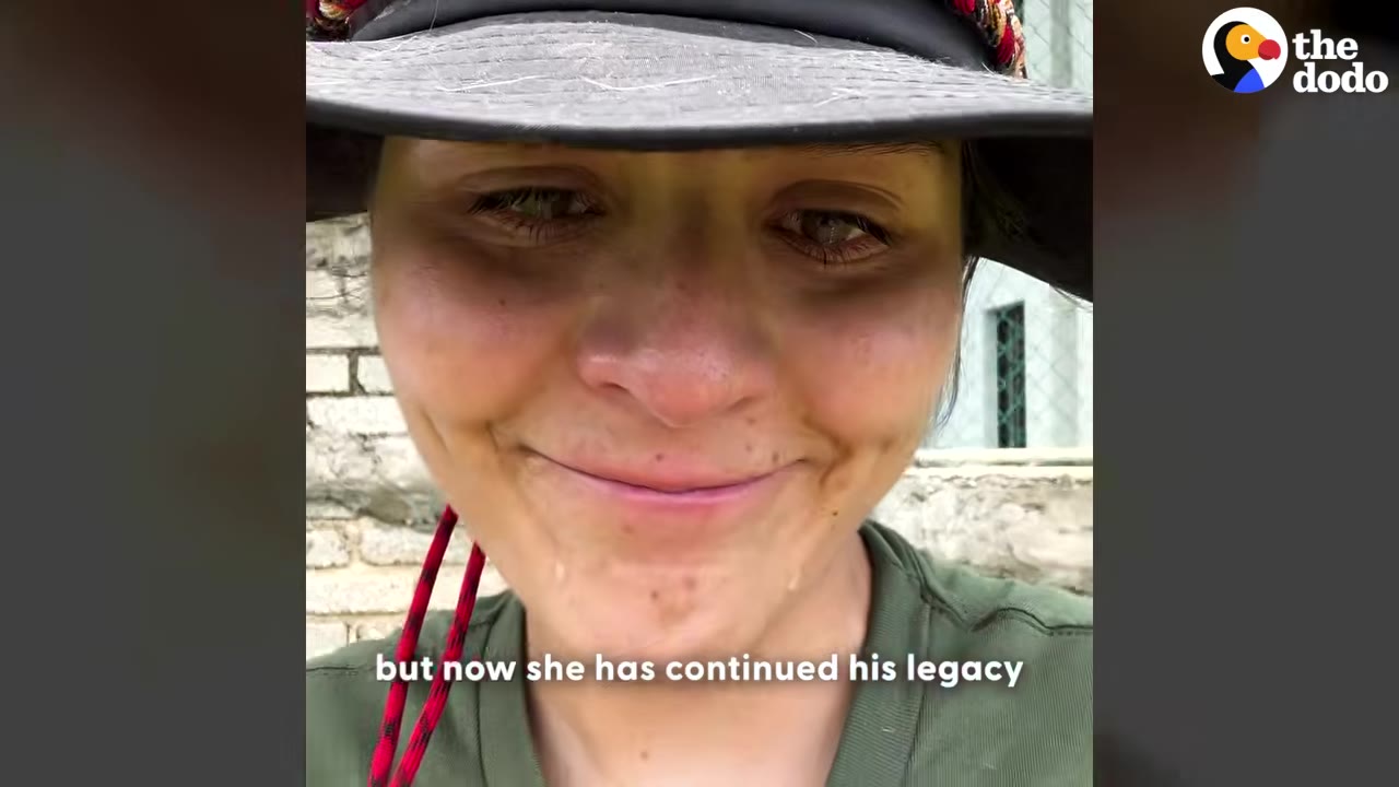 A close-up of a woman wearing a hat, with tears streaming down her face as she smiles sadly.