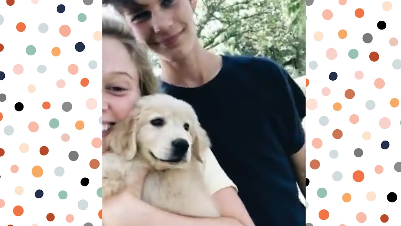 A young woman and a young man smiling as they hold a fluffy golden retriever puppy.