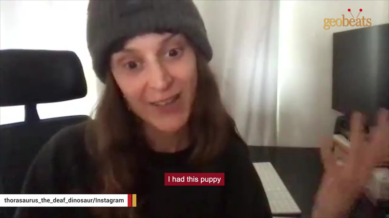 A woman wearing a dark grey beanie and a black shirt speaks to the camera, with a subtitle that reads 'I had this puppy'.