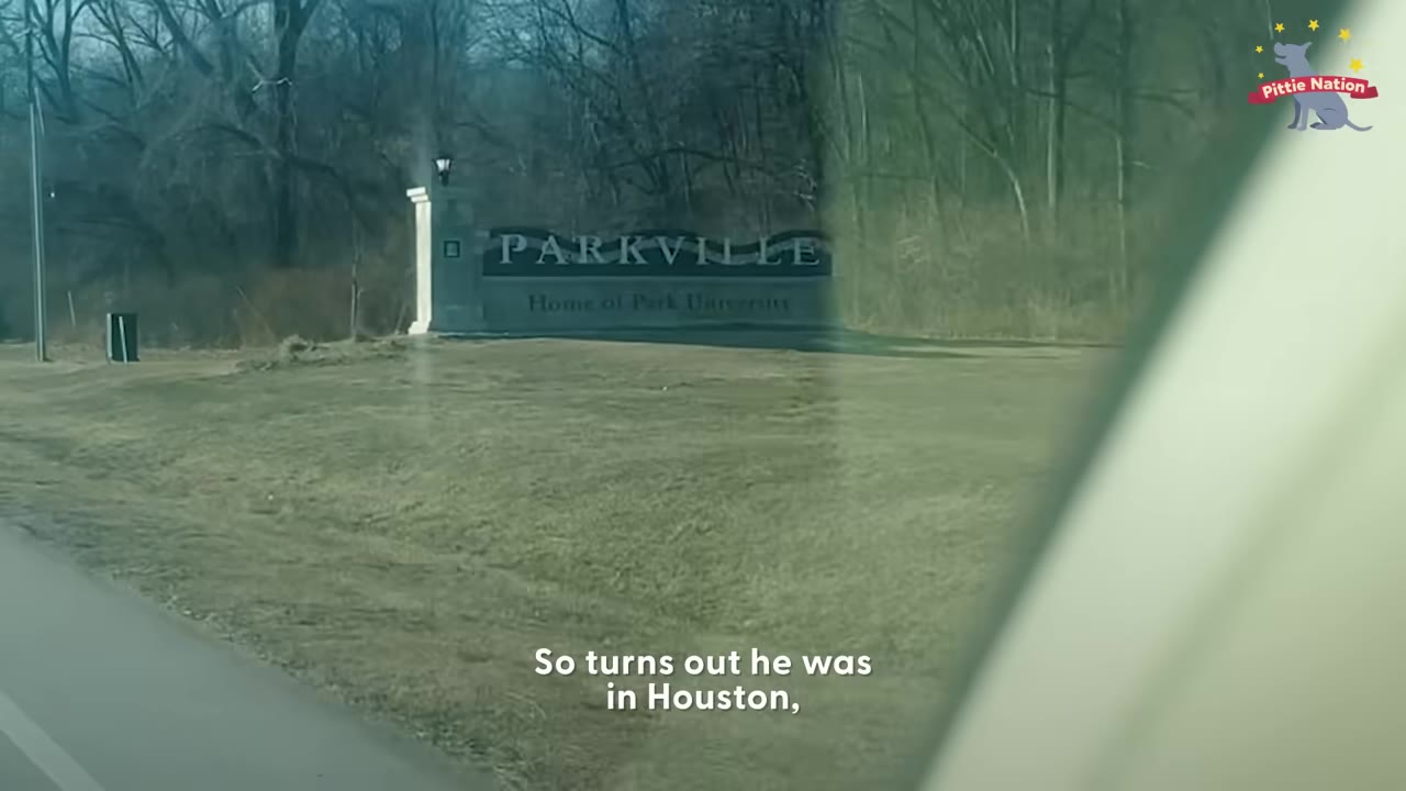A view from a car window of a sign that reads 'PARKVILLE Home of Park University' on a grassy lawn with trees in the background.