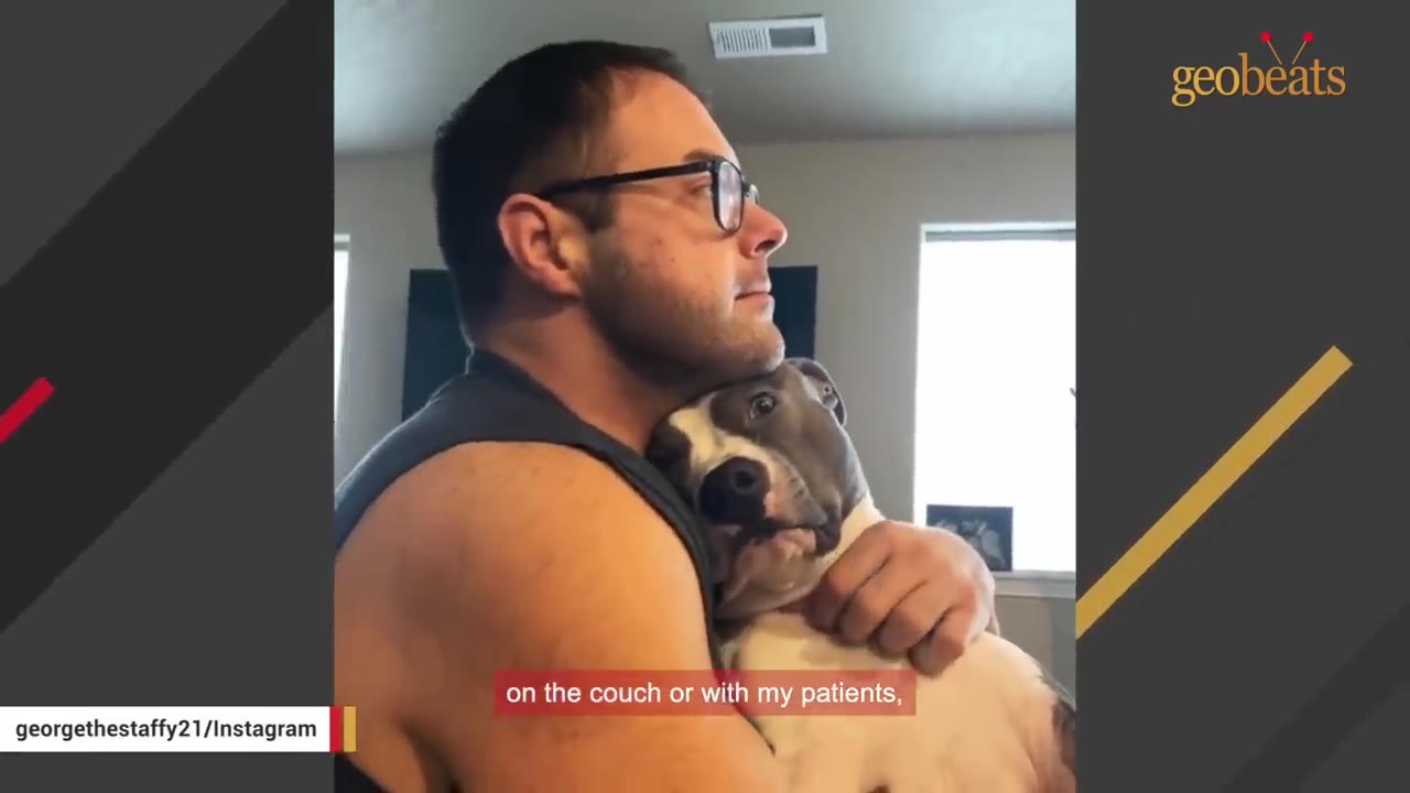 A man wearing glasses holds a grey and white dog close to his chest and neck.