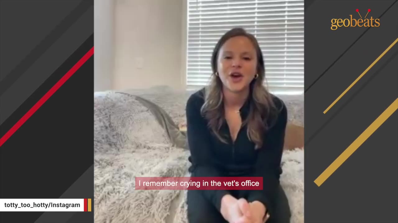 A woman sitting on a couch speaking to the camera with a subtitle that reads, 'I remember crying in the vet's office'.
