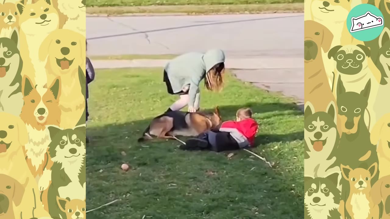A German Shepherd dog lies on a grassy lawn next to a child in a red jacket, while a person in a light green hoodie bends over to pet the dog.