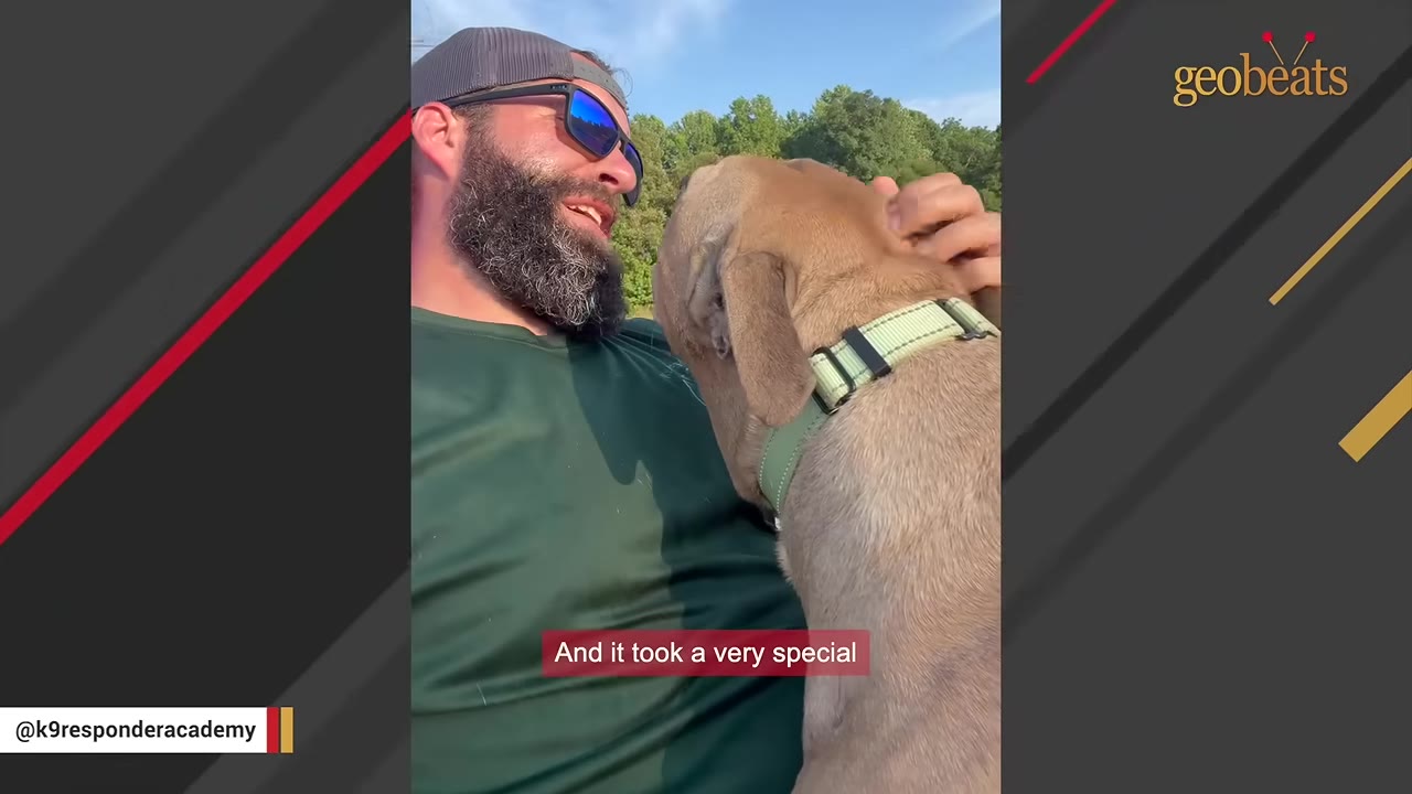 A bearded man wearing sunglasses and a cap smiles as a light brown dog leans against his chest.