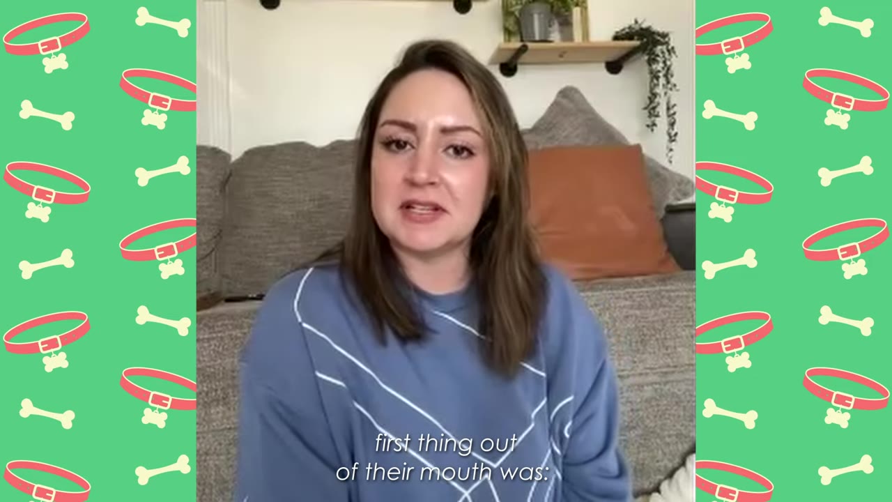 A woman with brown hair wearing a blue sweatshirt speaks to the camera while sitting on a couch.