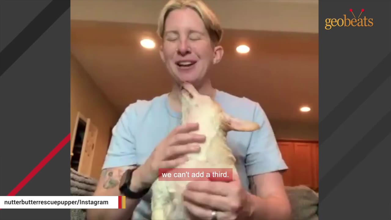 A woman with short blonde hair smiles with her eyes closed as she holds a small, light-colored dog close to her chest.