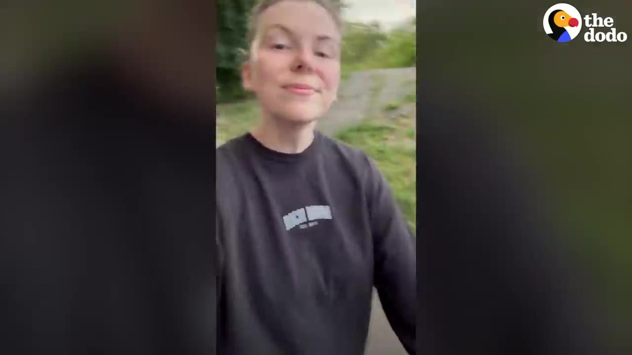 A young woman wearing a black sweatshirt walking outdoors on a path.