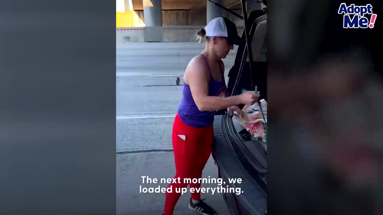 A woman wearing a purple tank top, red pants, and a baseball cap loads rescue equipment into the trunk of an SUV.