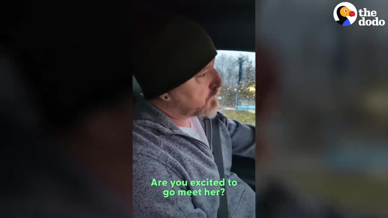 A man wearing a beanie and a gray fleece jacket seated in a vehicle with text reading 'Are you excited to go meet her?'.