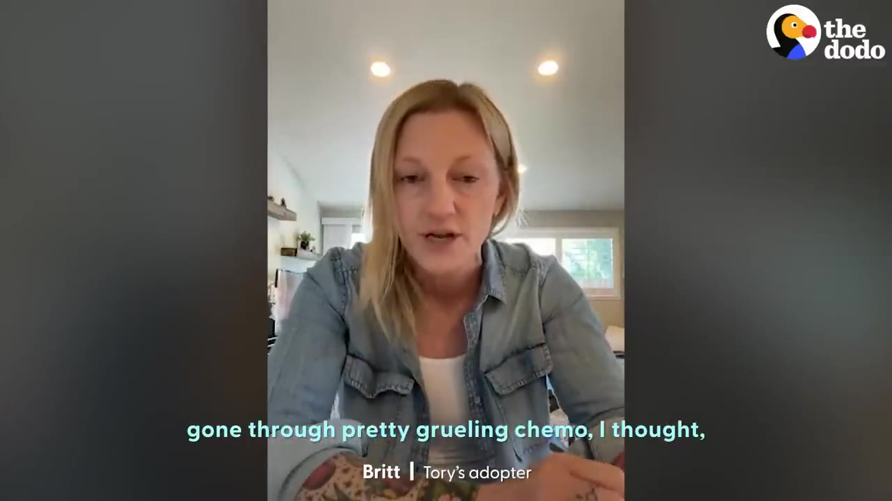 A woman named Britt, identified as Tory's adopter, speaking during a video interview while wearing a denim shirt.