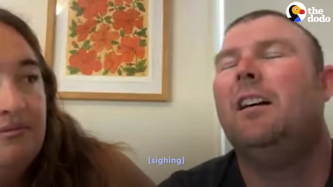 A man closing his eyes and sighing next to a woman during a video interview.
