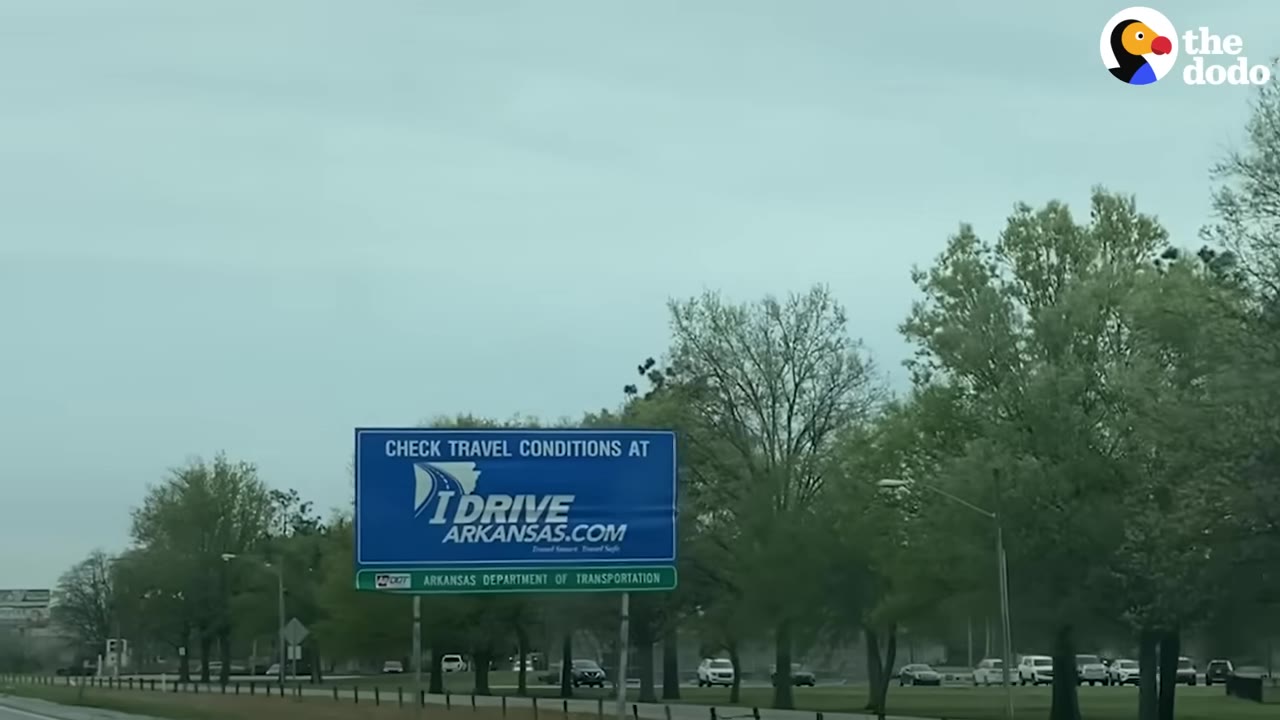 A highway billboard sign in Arkansas viewed from a vehicle during a road trip.